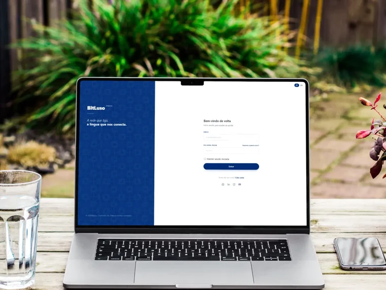Portal BitLuso aberto num portátil sobre uma mesa de café